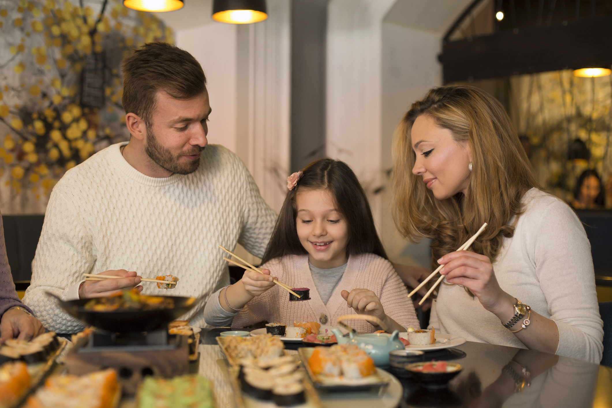 外国人が家族でお寿司を食べている写真